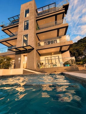 Un immeuble à plusieurs étages avec une piscine à l’avant.
