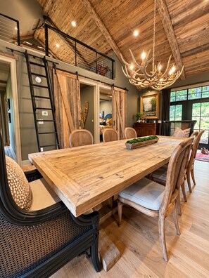 A spacious dining area with a large wooden table, wicker chairs, and a chandelier. - Luxury Private Mountain Spa - Trout Fishing + Trails (Copper Hill)