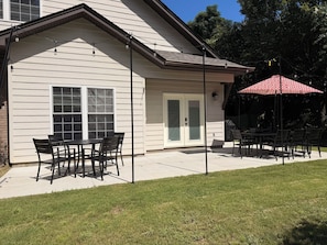 A house with a patio area featuring outdoor furniture and a red umbrella. - Spacious 3 Bed 3 Bath Tiger Den – 1 Mile to AU! (Auburn)