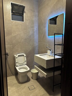 A modern bathroom with a toilet, bidet, and sink. - 3-bedroom apartment prime location (Amman)
