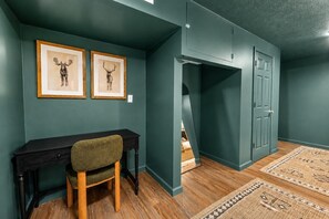 A room with a desk, chair, framed artwork, a door, and a patterned rug. - RRG Peaceful Escape: Hot Tub, Game Room, Sleeps 16 (Stanton)