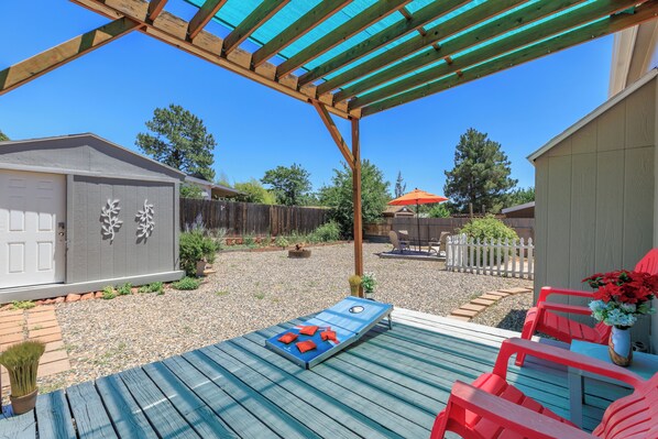 A covered patio area with a wooden deck, outdoor furniture, and a garden. - West Sedona Retreat - Near Trails & Red Rocks (Sedona)