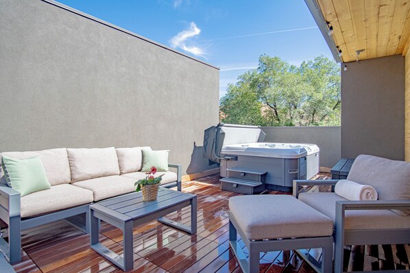 A covered outdoor area with a sofa, a chair, a table, and a hot tub. - River Street Lookout- Lux 3BD w/ Rooftop Views + Hot tub Downtown Hailey (Hailey)
