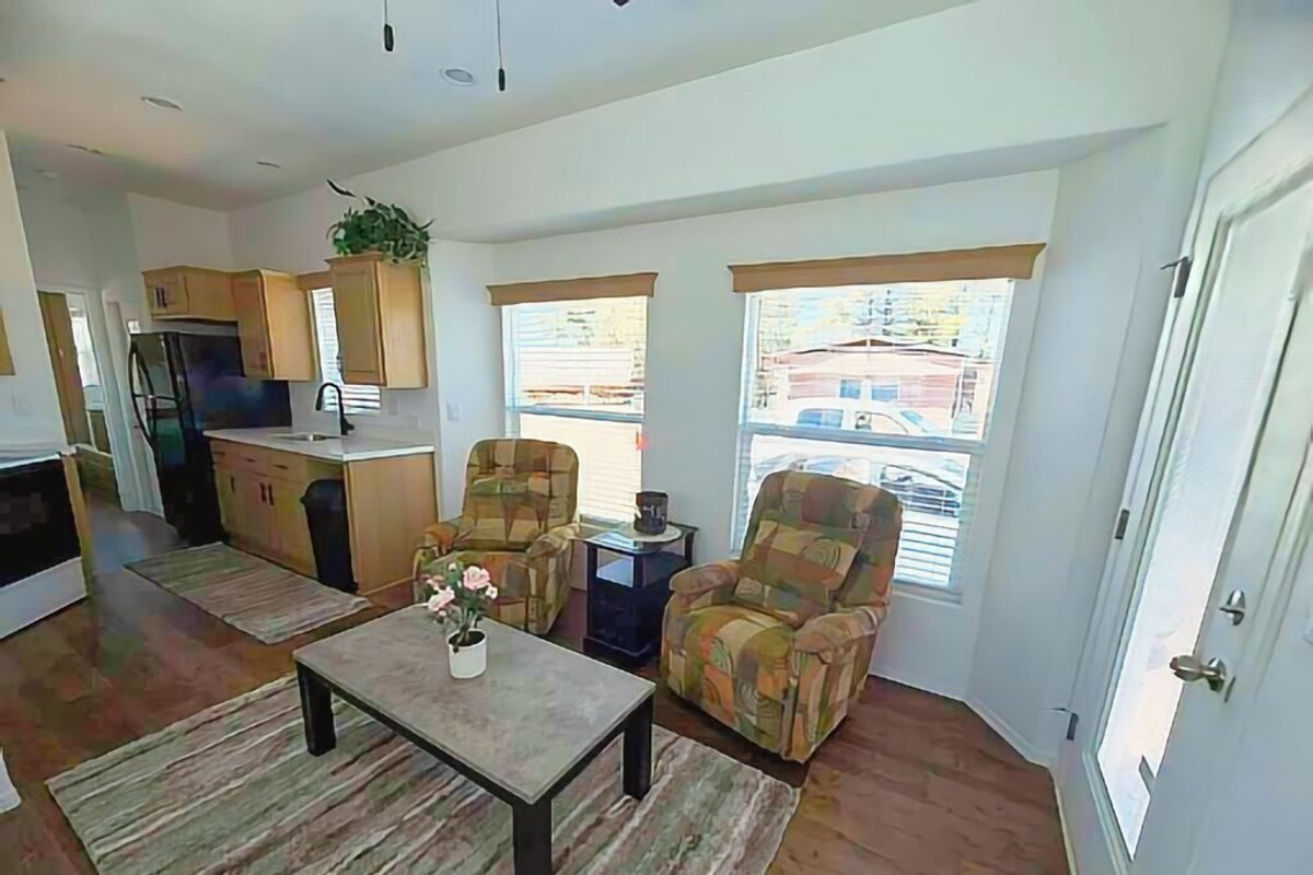 A modern living room with a sofa, a coffee table, and a view of the outside.