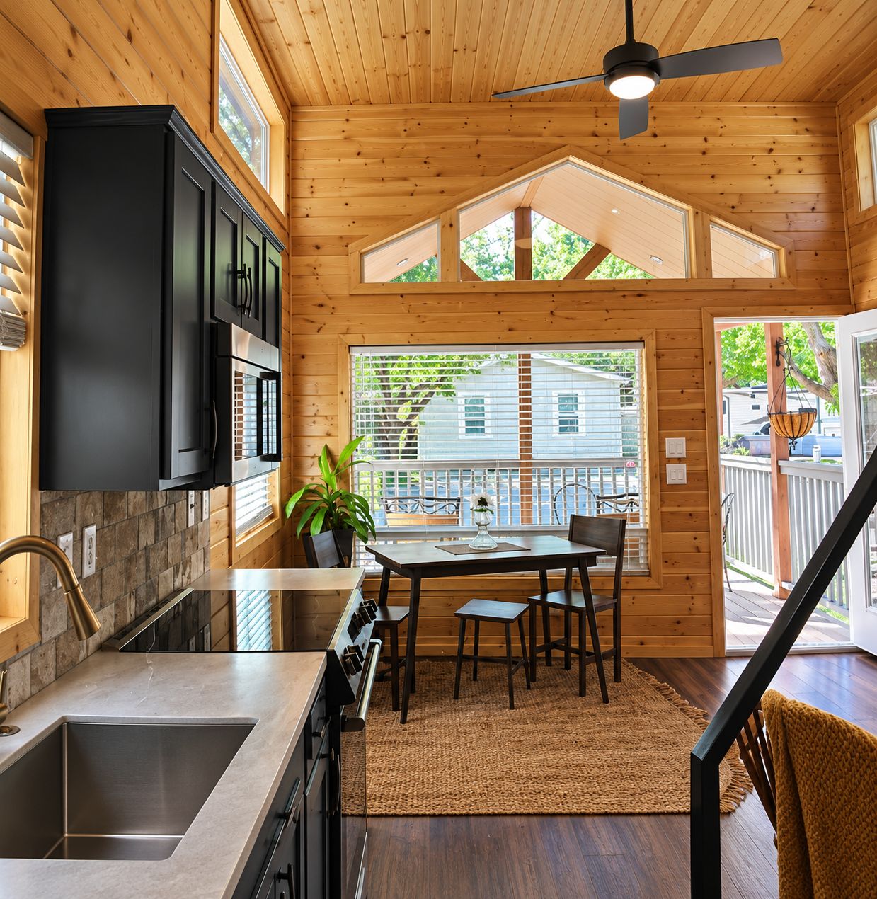 A wooden interior with a kitchen, dining area, and a view to the outside.