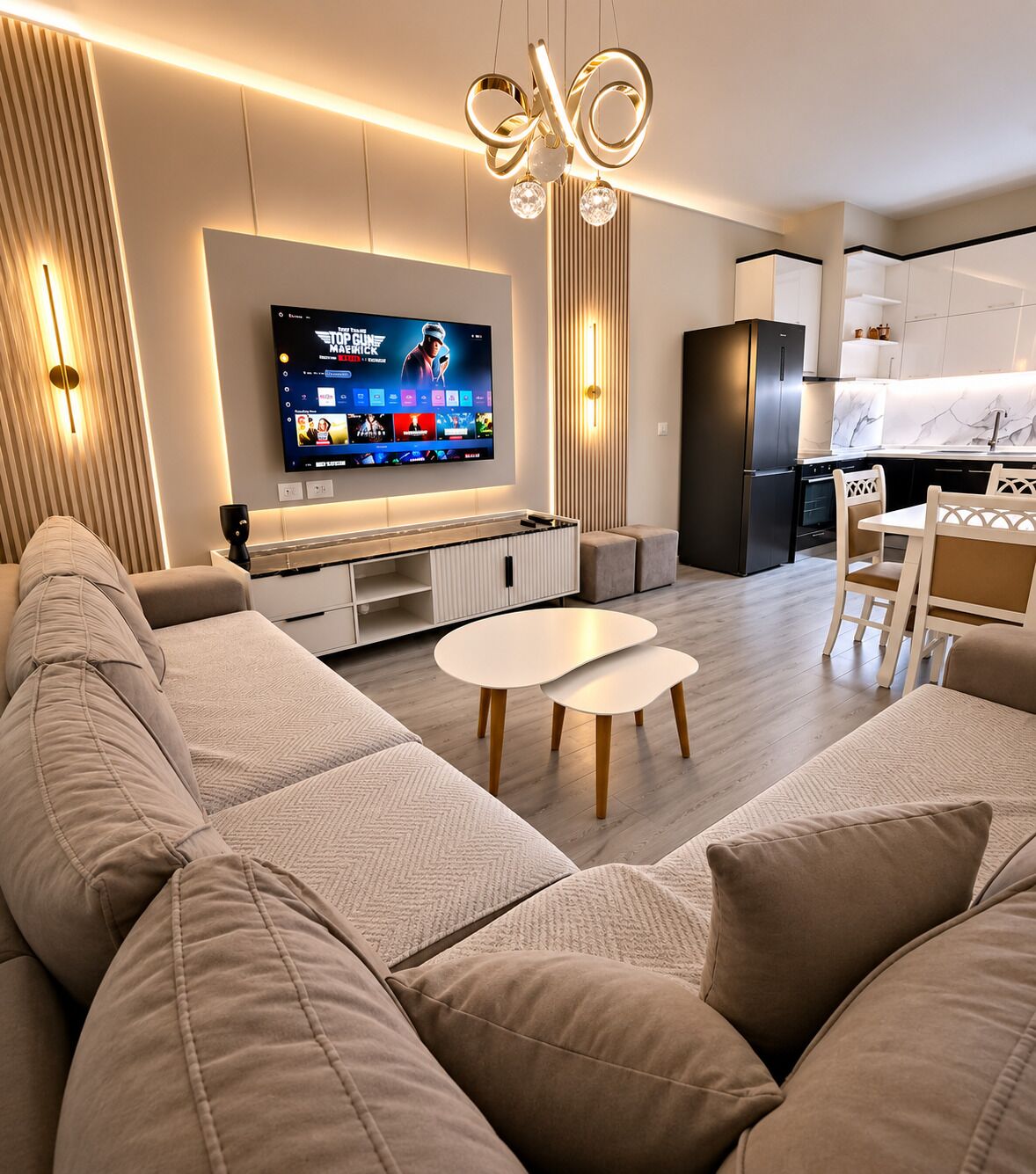 Un soggiorno moderno con un'ampia TV a schermo piatto, un divano, un tavolino da caffè e un'area pranzo con sedie.