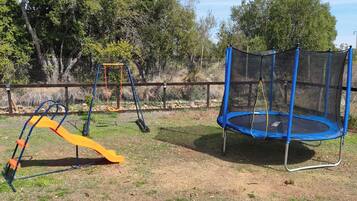 Un'area giochi con un trampolino e uno scivolo.