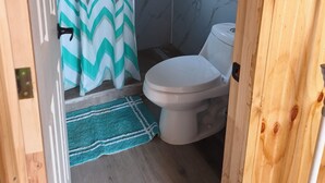 A bathroom with a shower, toilet, and a patterned curtain.