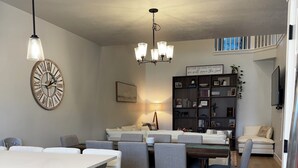 A modern kitchen with a dining area, a built-in oven, and a large clock on the wall. - The Windy Sage - peaceful and family friendly home for any event; sleeps 10+ (Eagle Mountain)