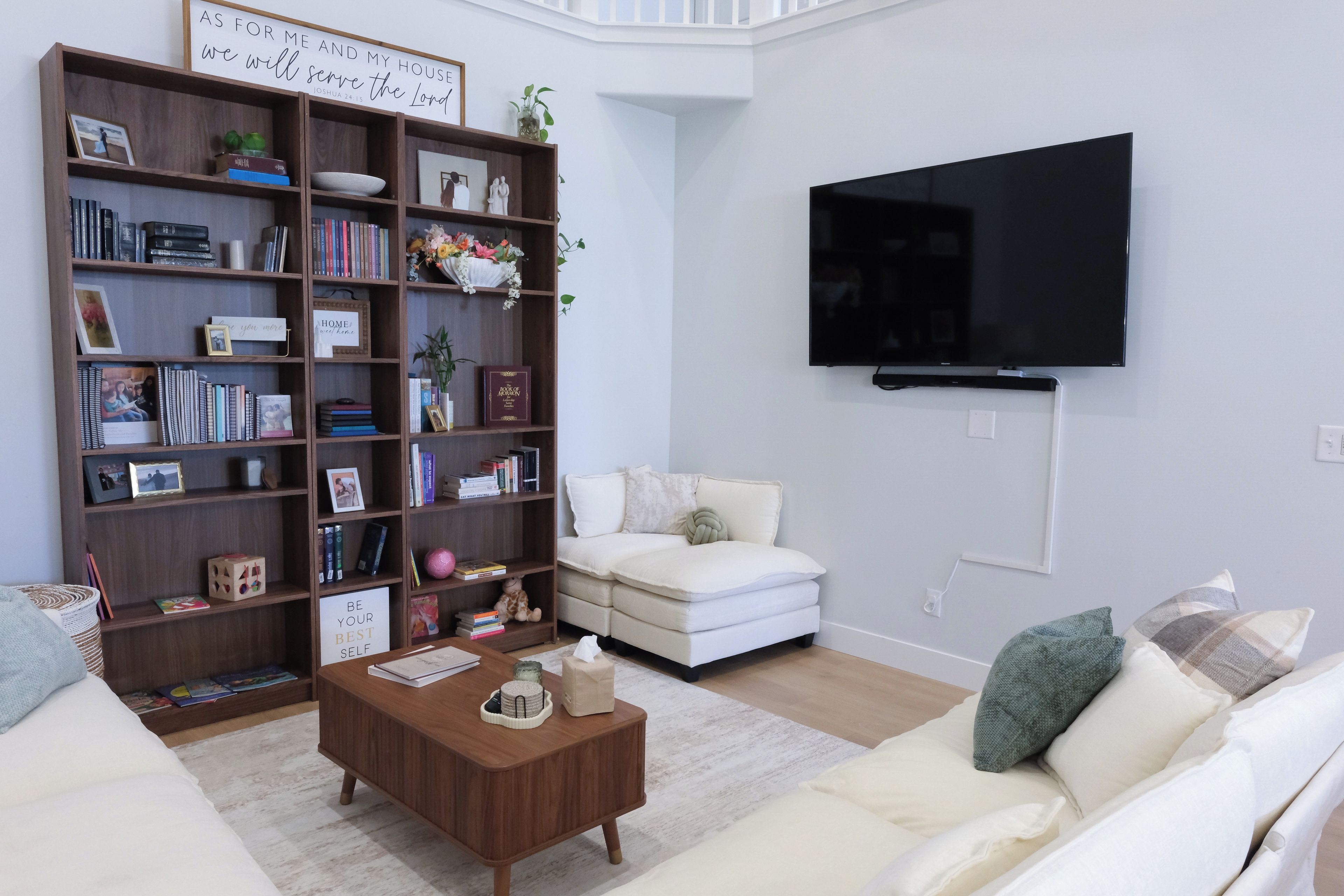 Un salon comprenant une bibliothèque, un téléviseur à écran plat, un canapé et une table basse.