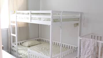 A bunk bed room with a crib attached to the right side.
