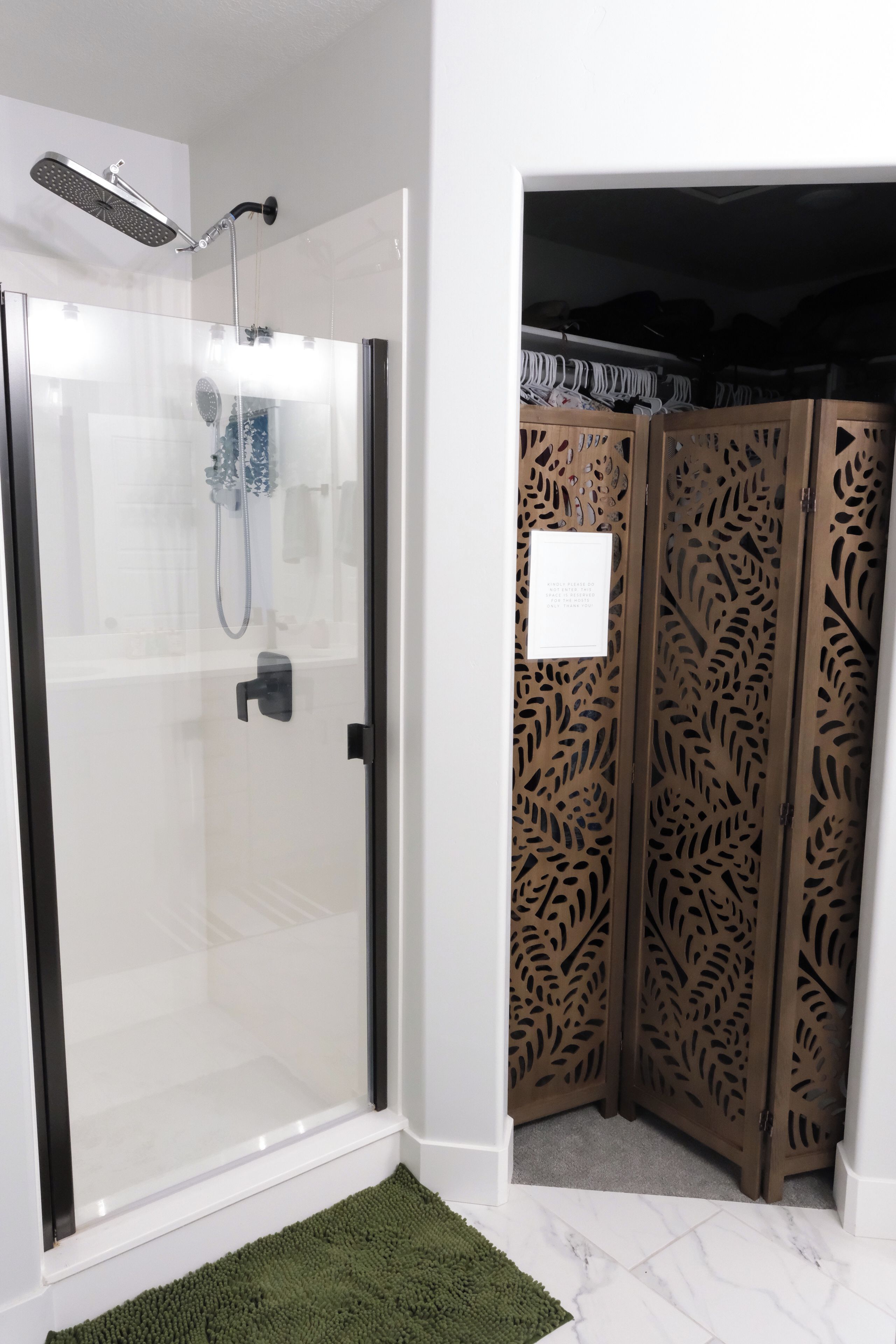 A glass-enclosed shower area with a handheld showerhead and a wall-mounted faucet.