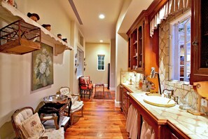 A narrow hallway with a dining area on one side, a kitchen on the other, and a window providing natural light. - Phenomenal Private Estate with pool and spa in San Juan Capistrano.4-bed, 6 bath (San Juan Capistrano)