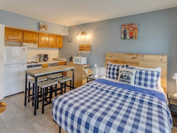 A compact room with a bed, a small kitchenette, and a dining area. - King Bed Studio | Indoor Pool & Hot Tub | Walk to Dining | Minutes to Loon (Lincoln)