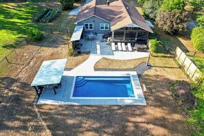 A residential property with a swimming pool, patio seating, and a covered outdoor area. - Sandy Shores Pool & Spa Retreat w/Hot Tub/Beach (Summerton)