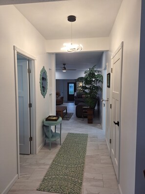 A hallway with a ceiling fan, a dining area with a table and chairs, and a large potted plant. - 3-bedroom house in soothing Manistique with plenty of space to relax (Manistique)