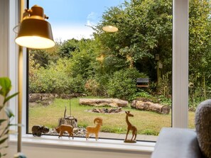 A window with a view of a garden featuring a deer, a fox, and a bird feeder. - "Gesine" - 20km to the fjord by Interhome (Toftlund)