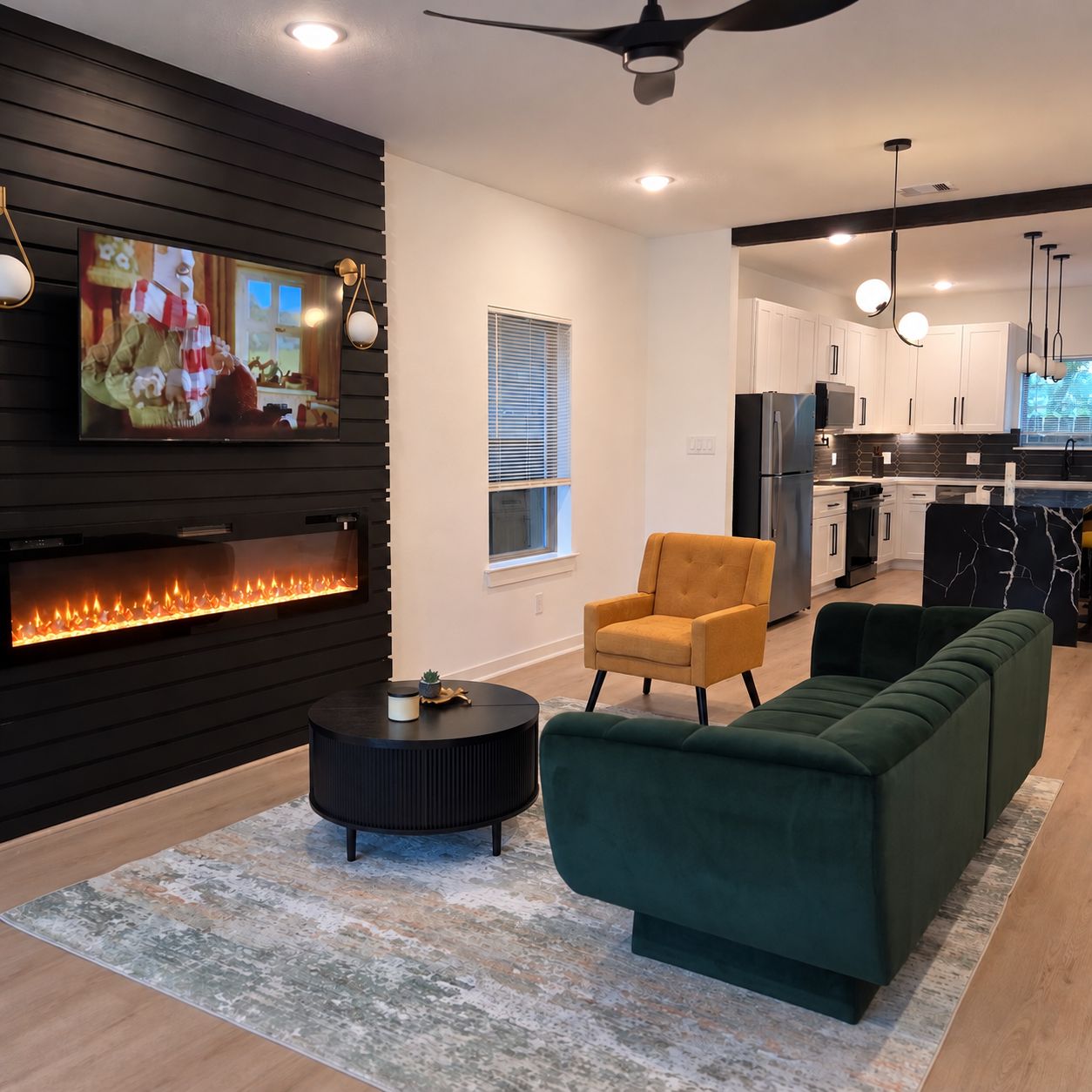 A modern living room with a fireplace, a sofa, a coffee table, and a television mounted on the wall.