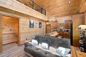A cozy cabin interior with a dining area, kitchen, and a balcony. - Chestnut Tower – Incredible Mount LeConte Views, Hot Tub & Game Room (Gatlinburg)