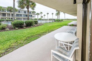 Eine Hotelterrasse mit Schwimmbad, Sitzgelegenheiten im Freien und Blick auf den Ozean.