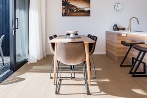 Eine moderne Küche mit einem Holztisch, Stühlen und einer eingebauten Spüle.