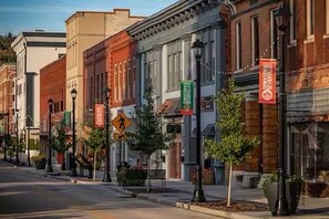 A street lined with historic buildings, some with storefronts and signage, and a pedestrian crossing sign. - Beautiful Craftsman Lakehouse in Dandridge by Douglas Lake (Dandridge)
