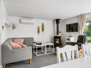 A modern living room with a sofa, coffee table, and a fireplace. - "Rəzvan" -  from the sea by Interhome (Hadsund)