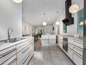 A modern kitchen with a central island, built-in appliances, and pendant lighting. - "Carlina" -  from the sea by Interhome (Hadsund)