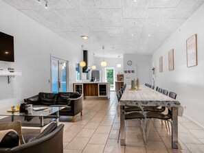 Ein modernes Wohnzimmer mit einer Couch, einem Couchtisch und einem Essbereich mit Tisch und Stühlen.