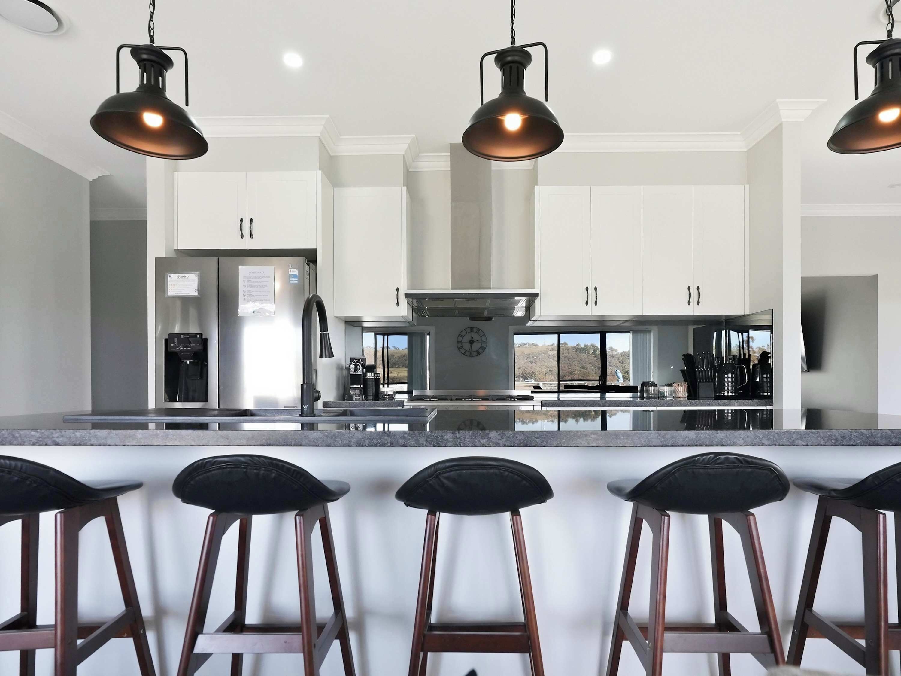 A modern kitchen with a central island, stainless steel appliances, and pendant lighting.