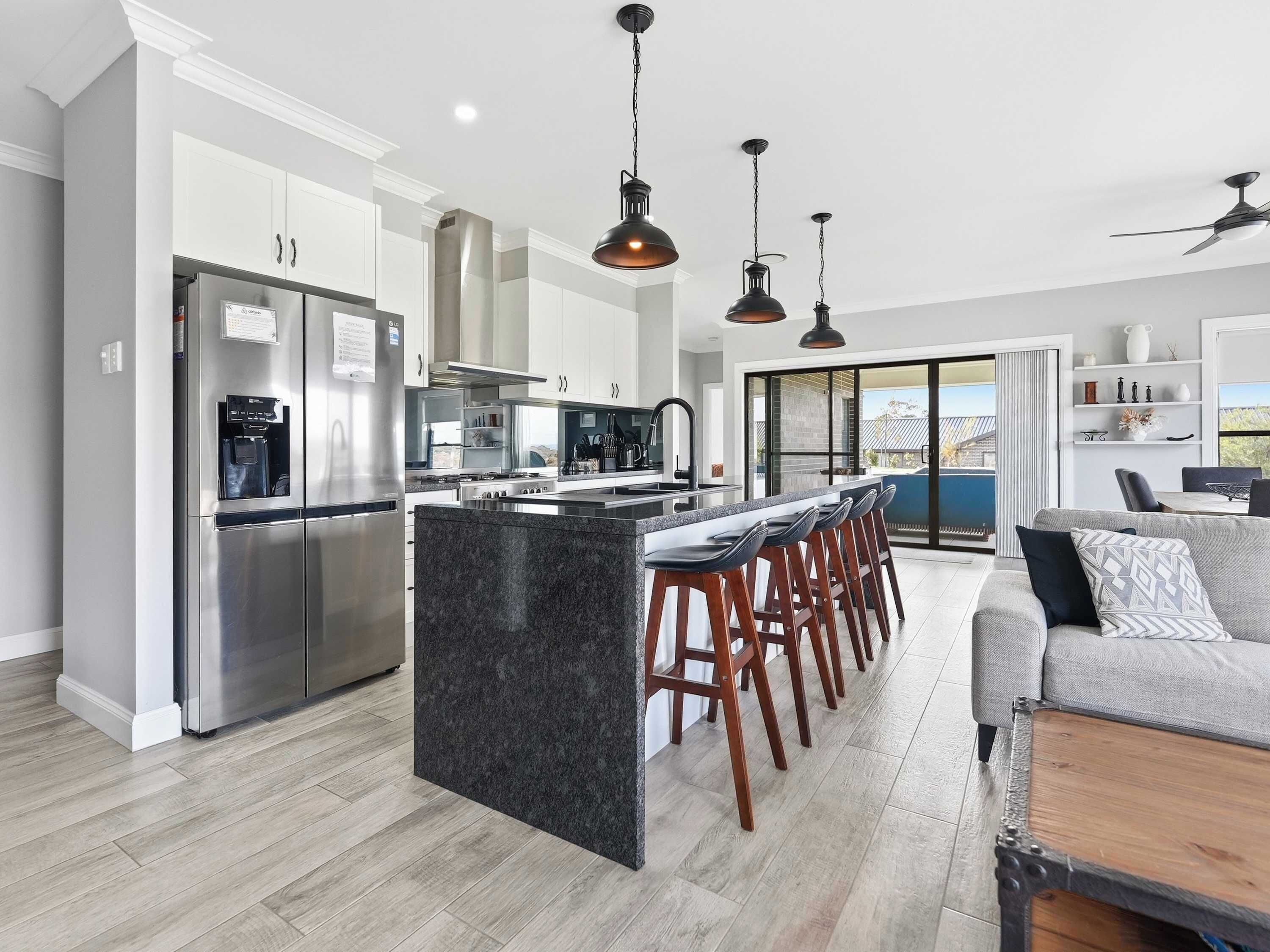A modern kitchen with a central island, stainless steel appliances, and pendant lighting.
