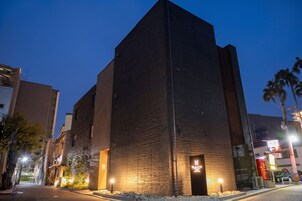 Un edificio alto y moderno con techo plano y una entrada espaciosa.