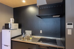 Cozinha compacta com micro-ondas, torradeira e forno embutido.