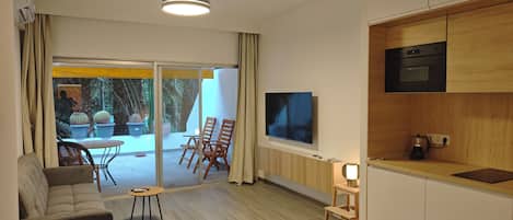 Una sala de estar moderna con un sofá, una mesa de centro y un televisor montado en la pared.