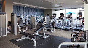 A gym with various exercise machines, including treadmills and weight benches. - The Golden Hour Luxury Midtown Stay with Rooftop pool (Atlanta)