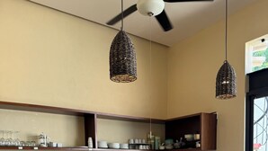 A modern kitchen with a central island, bar stools, and pendant lighting. - Casa Xunan (Mérida)
