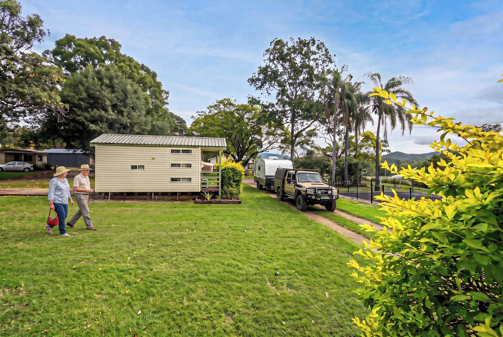 A residential area with a single-story house, a parked truck, and a trailer.