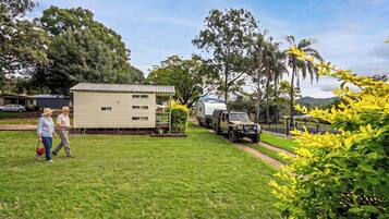 A residential area with a single-story house, a parked truck, and a trailer.