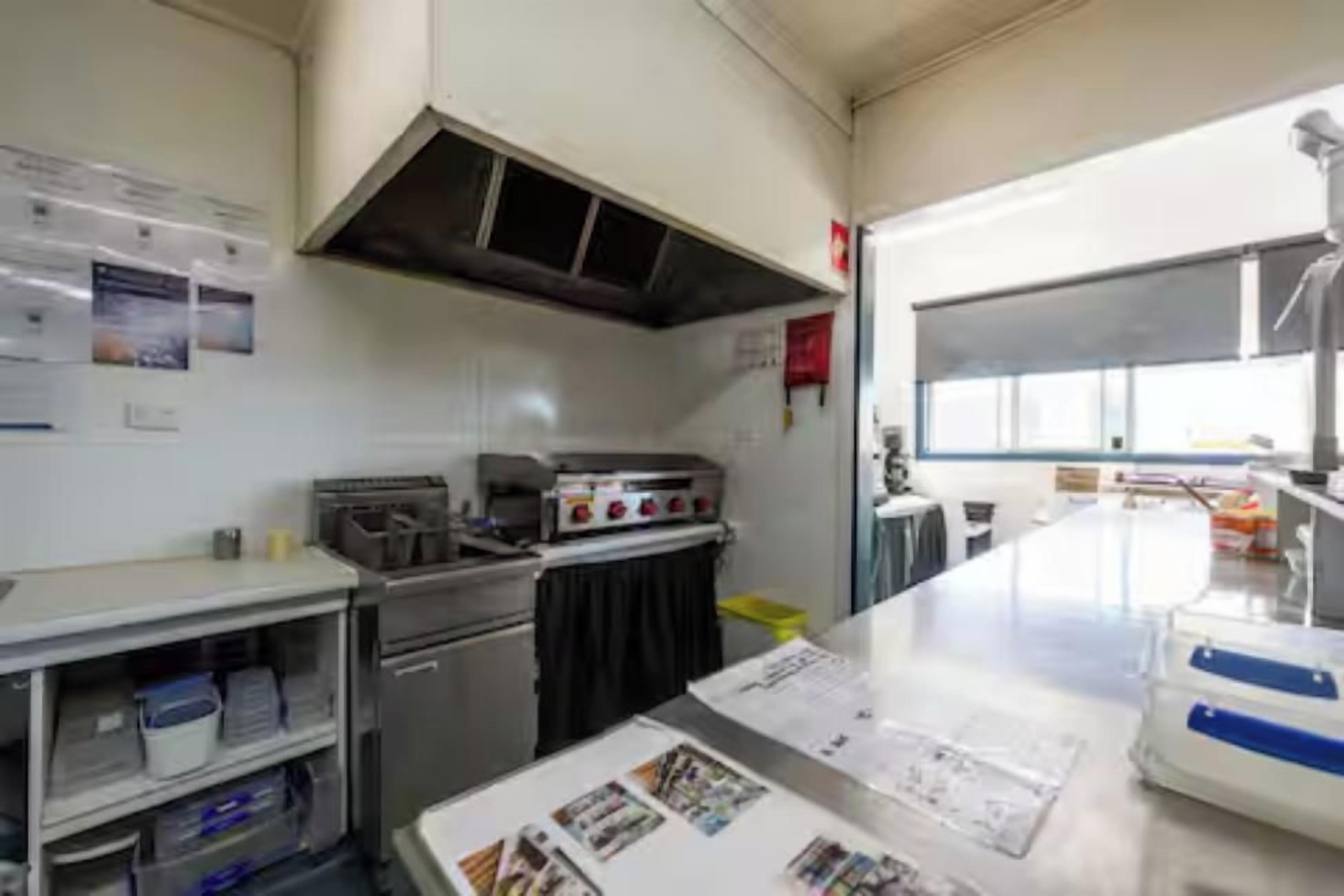A kitchen with stainless steel appliances, a gas stove, and a window providing natural light.