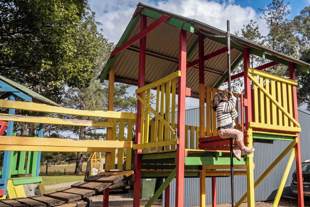 A playground with a climbing structure and a slide.