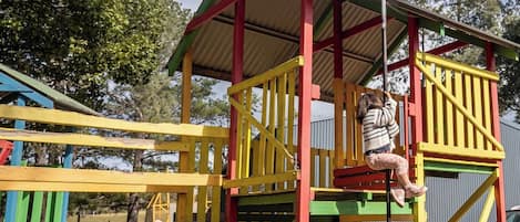 Ein Spielplatz mit einer Kletteranlage und einer Rutsche.