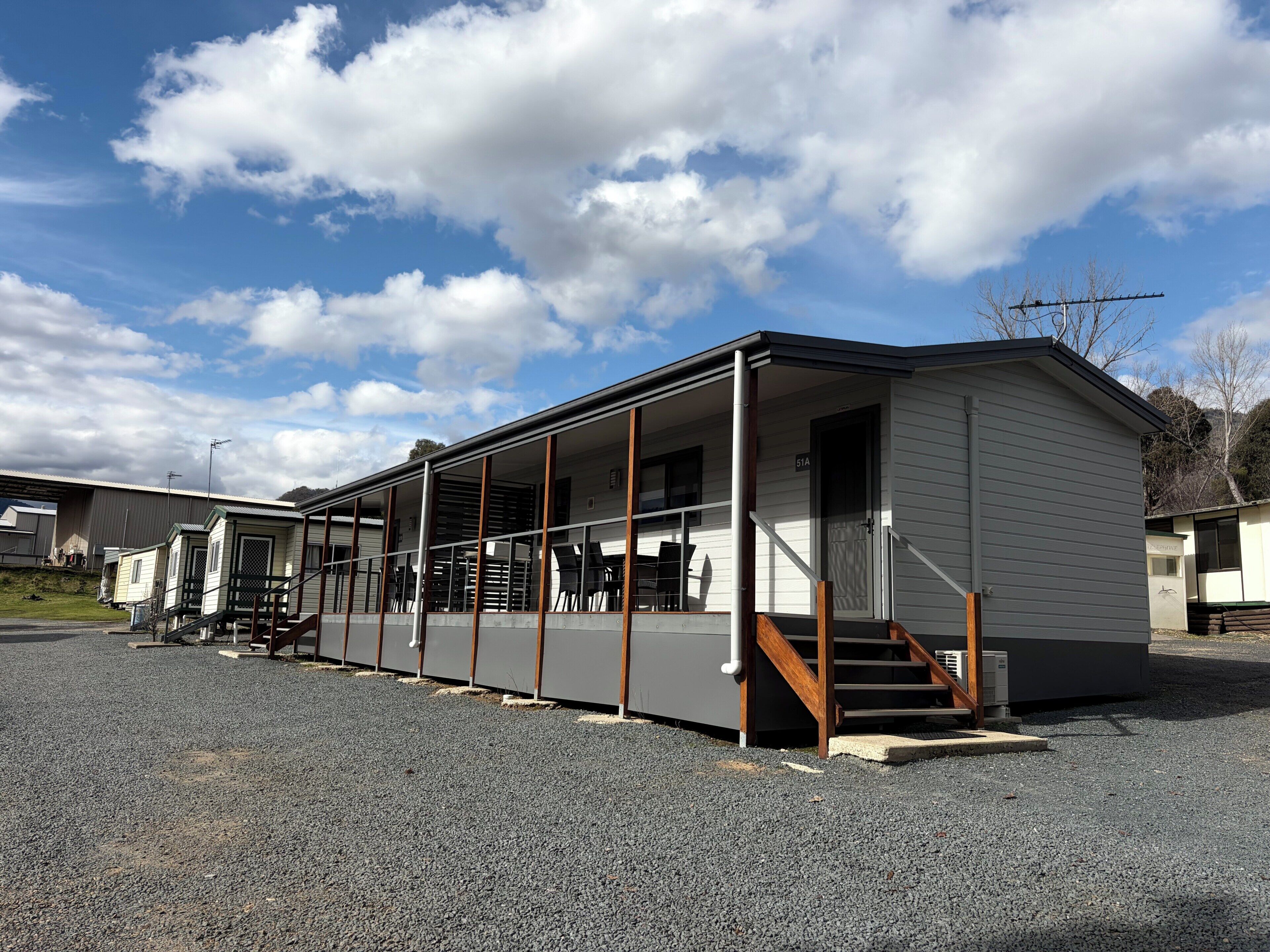 A single-story mobile home with a covered porch and a staircase leading to the entrance.