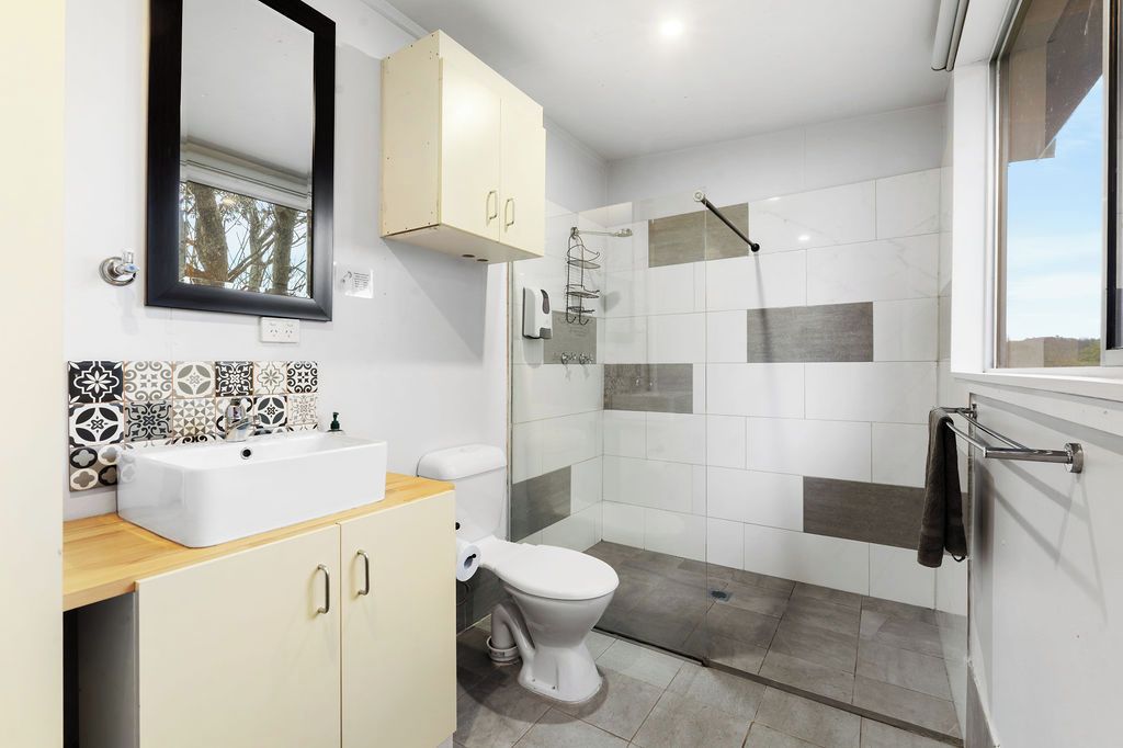 A bathroom with a white sink, toilet, and shower.