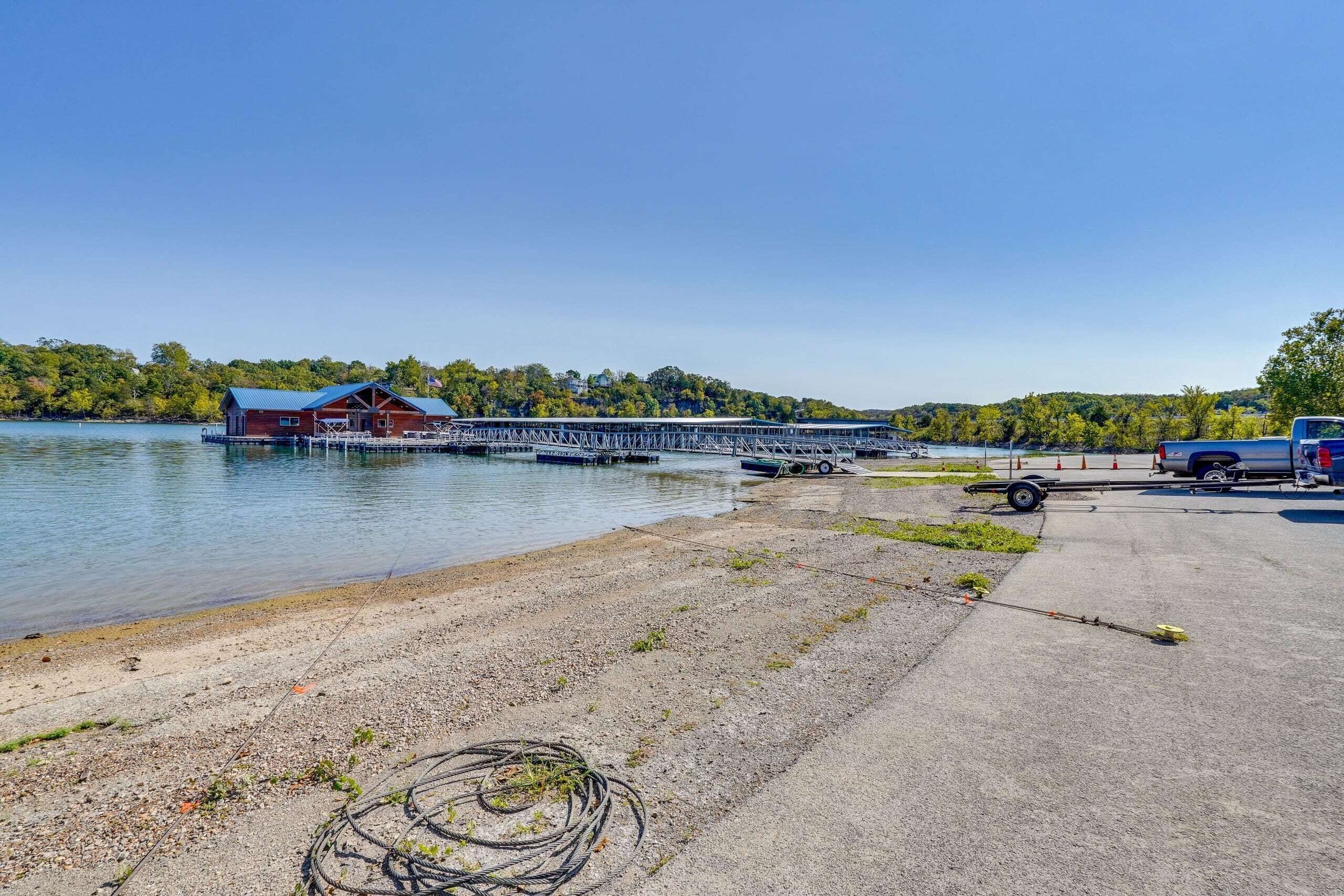 A dock with a boat, a building with a blue roof, and a clear sky.