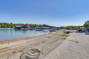 A dock with a boat, a building with a blue roof, and a clear sky. - Lakeside 2BR Cabin Table Rock Lake - Sunset Views (Eagle Rock)