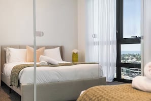 A hotel room with a bed, a window with a view, and a curtain. - Skyline & Bay Views Stylish 3BR Southbank Retreat (Southbank)