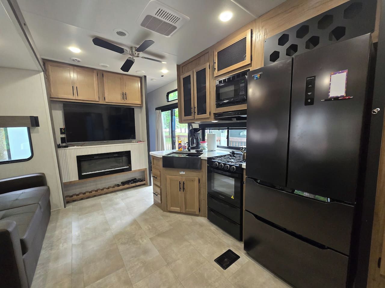 A compact kitchen with built-in appliances, wooden cabinets, and a central island.