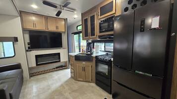 A compact kitchen with built-in appliances, wooden cabinets, and a central island.