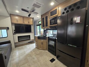 A compact kitchen with built-in appliances, wooden cabinets, and a central island.