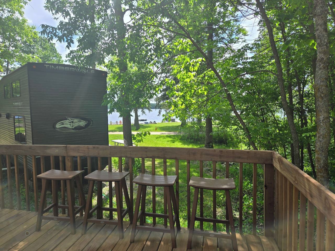 A wooden deck with a view of a lake and trees.